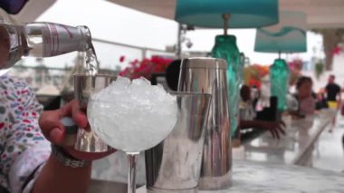Barman is making cocktail with ice and coctail shaker at club. Part of coctail making series. Slow motion shooting
