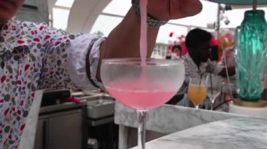 Barman is making cocktail with ice and coctail shaker at club. Part of coctail making series. Slow motion shooting