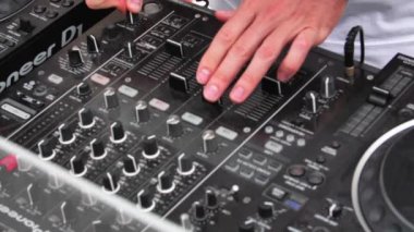 Hands of DJ on Pioneer mixing console while he is doing his set. Slow motion