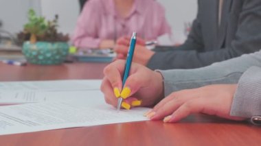 Document is signded by woman, hands closeup, slow motion