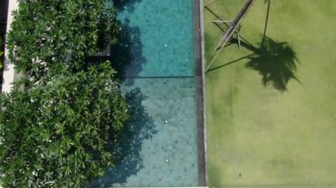 Drone flying over a private pool in a cottage by the sea at high tide. Aerial.