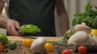 Profesyonel şef yeşil dolmalık biber hazırlar ve keser. Ağır çekimde kapat