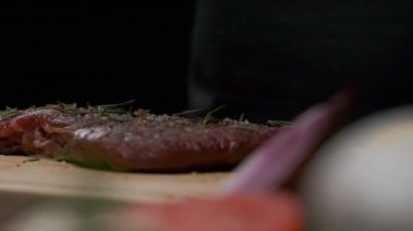 Professional chef applies greens to meat steak. Slow motion close up.