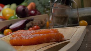 Kesme tahtasının üzerinde iki dilim somon balığı var. Ağır çekimde kapat