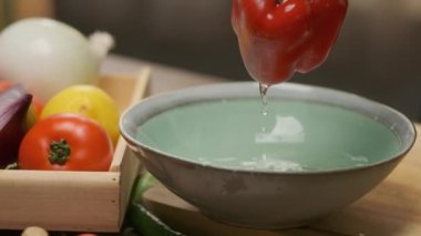 Professional chef prepares and cuts red bell pepper. Close up slow motion