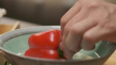 Professional chef prepares and cuts red bell pepper. Close up slow motion