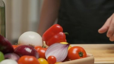 Professional chef prepares and cuts red bell pepper. Close up slow motion