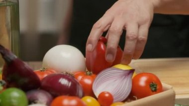 Professional chef prepares and cuts red bell pepper. Close up slow motion
