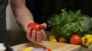 Professional chef prepares and cuts red bell pepper. Close up slow motion