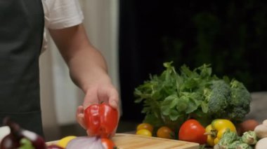 Professional chef prepares and cuts red bell pepper. Close up slow motion
