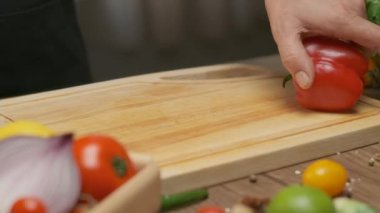 Professional chef prepares and cuts red bell pepper. Close up slow motion