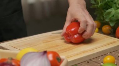 Professional chef prepares and cuts red bell pepper. Close up slow motion
