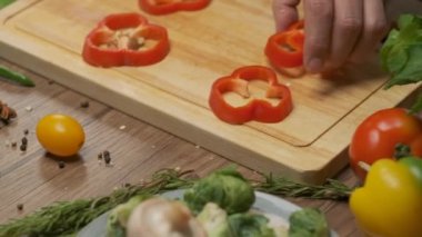 Professional chef prepares and cuts red bell pepper. Close up slow motion