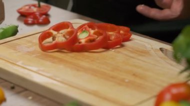 Professional chef prepares and cuts red bell pepper. Close up slow motion