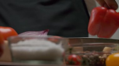 Professional chef prepares and cuts red bell pepper. Close up slow motion