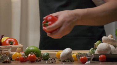 Professional chef prepares and cuts red bell pepper. Close up slow motion