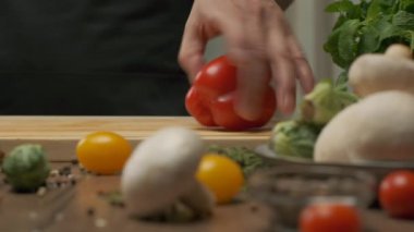 Professional chef prepares and cuts red bell pepper. Close up slow motion