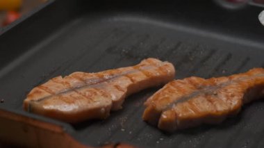 Profesyonel şef ızgarada kırmızı balık filetosu pişiriyor. Yavaş çekim