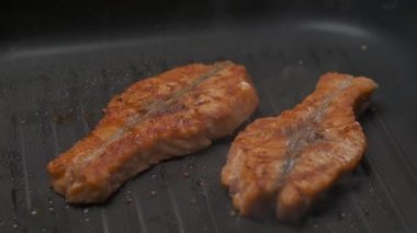 Profesyonel şef ızgarada kırmızı balık filetosu pişiriyor. Yavaş çekim