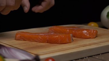 Profesyonel şef kırmızı balık bifteğini kızartma için hazırlar. Ağır çekimde kapat.