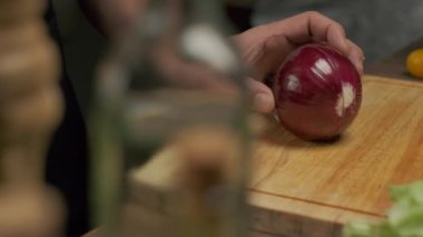 Profesyonel şef kırmızı soğan hazırlar ve keser. Ağır çekimde kapat