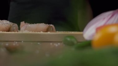 Profesyonel şef beyaz balık bifteğine biber serper. Ağır çekimde kapat