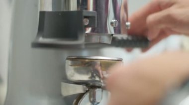 Barista makes coffee on a coffee machine, slow motion close-up.