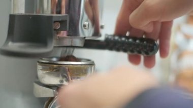 Barista makes coffee on a coffee machine, slow motion close-up.