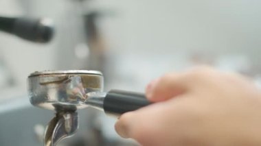 Barista makes coffee on a coffee machine, slow motion close-up.