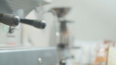 Barista makes coffee on a coffee machine, slow motion close-up.