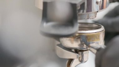 Barista makes coffee on a coffee machine, slow motion close-up.