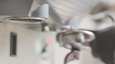 Barista makes coffee on a coffee machine, slow motion close-up.