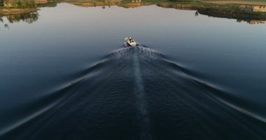 Young couple in the boat on beautiful lake. Drone aerial, slow motion