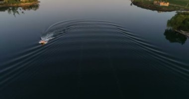 Young couple in the boat on beautiful lake. Drone aerial, slow motion