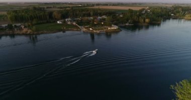 Young couple in the boat on beautiful lake. Drone aerial, slow motion