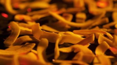 Coconut chips on a dark table close-up. Black background, slow motion.