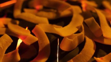 Coconut chips on a dark table close-up. Black background, slow motion.
