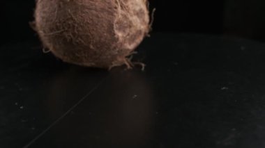 Coconut spinning on a black background, slow motion