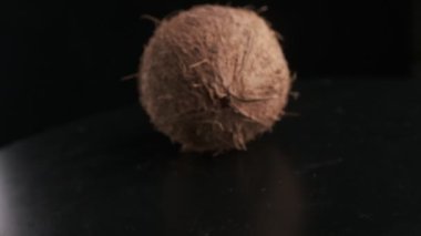 Coconut spinning on a black background, slow motion