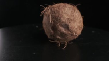 Coconut spinning on a black background, slow motion