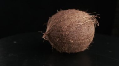 Coconut spinning on a black background, slow motion