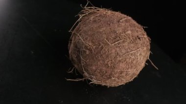 Coconut spinning on a black background, slow motion