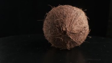Coconut spinning on a black background, slow motion