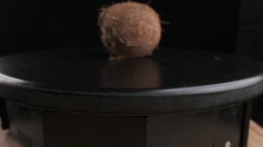 Coconut spinning on a black background, slow motion
