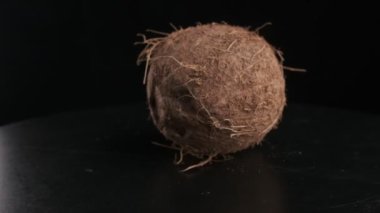 Coconut spinning on a black background, slow motion