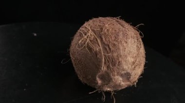 Coconut spinning on a black background, slow motion