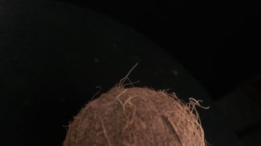 Coconut spinning on a black background, slow motion
