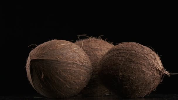 Three Coconuts Spinning Black Background Slow Motion — Vídeo de stock