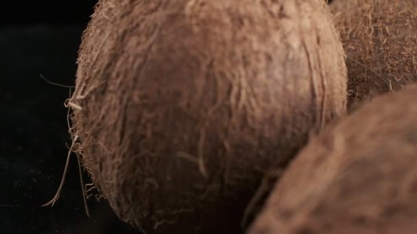 Three Coconuts Spinning Black Background Slow Motion — Αρχείο Βίντεο