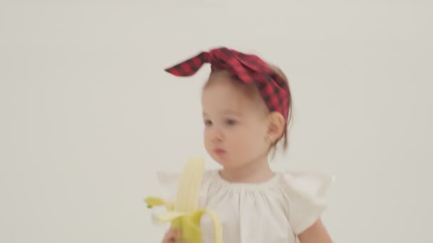 Niña Diadema Cuadros Falda Está Comiendo Plátano Grande Primer Plano — Vídeo de stock